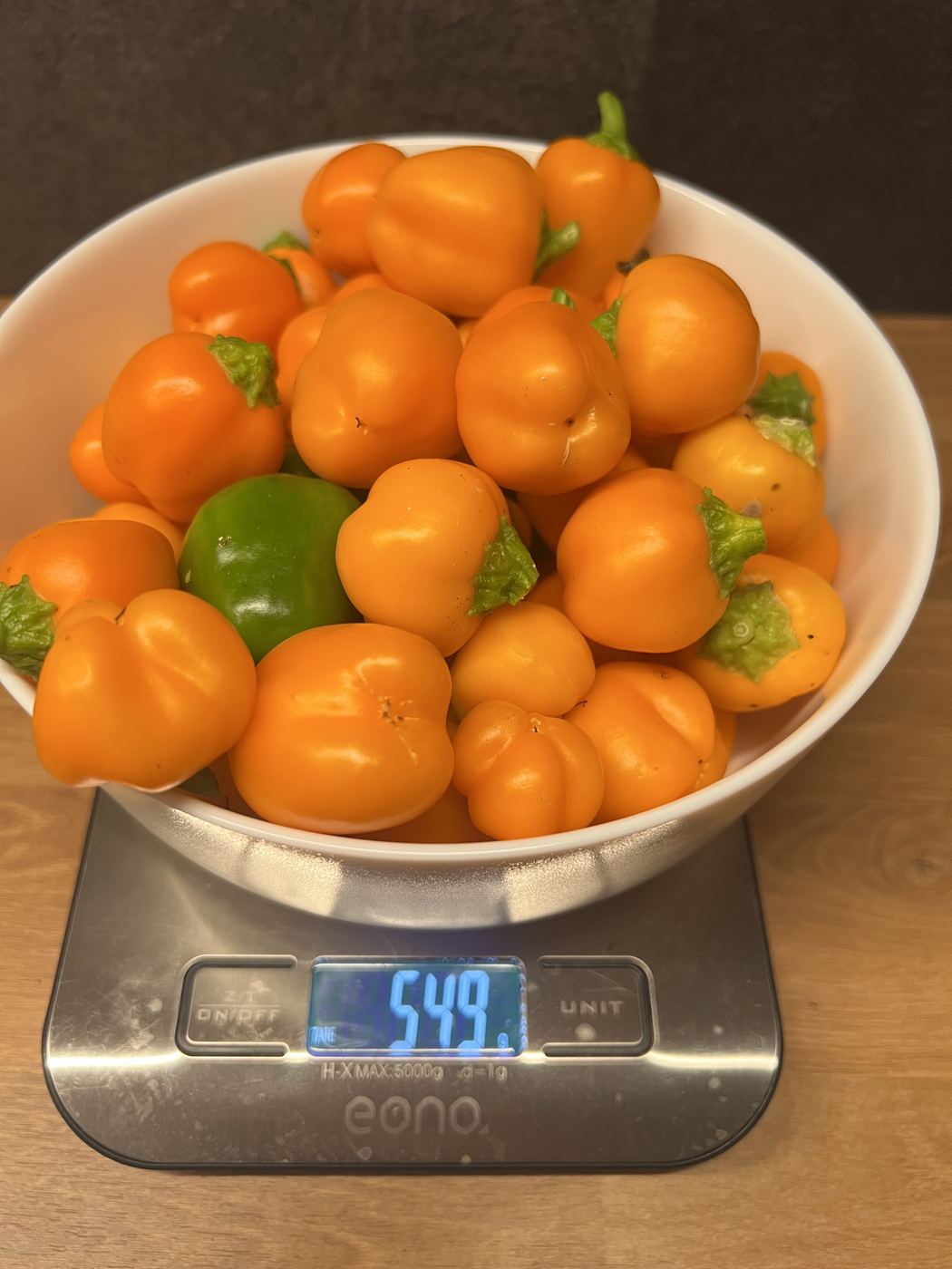 Schüssel mit orangen Kirschpaprika auf einer Küchenwaage